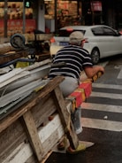 A Scrap Guru team member handing cash to a happy customer beside a scrapped car.