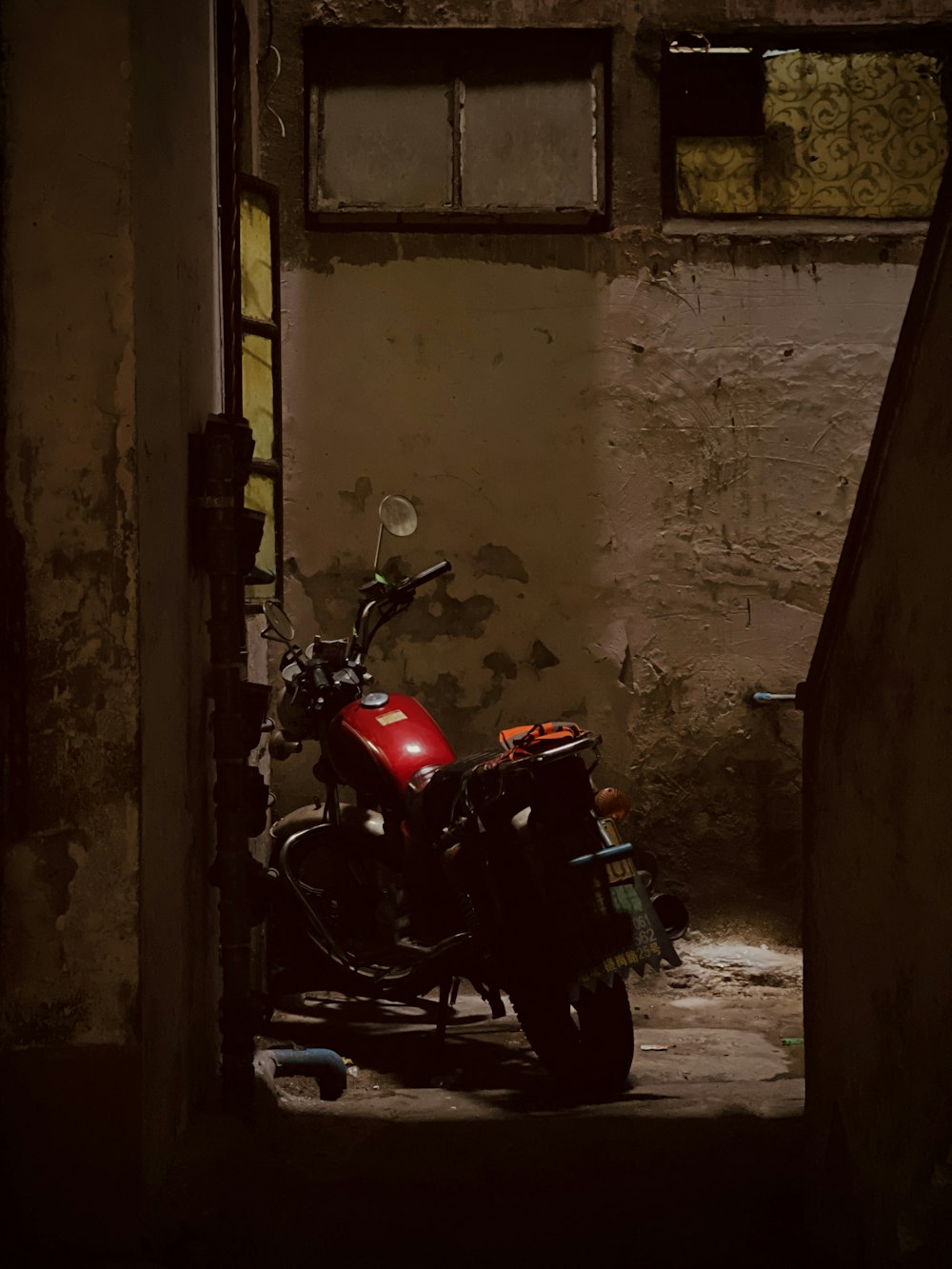 a red motorcycle parked in a doorway of a building