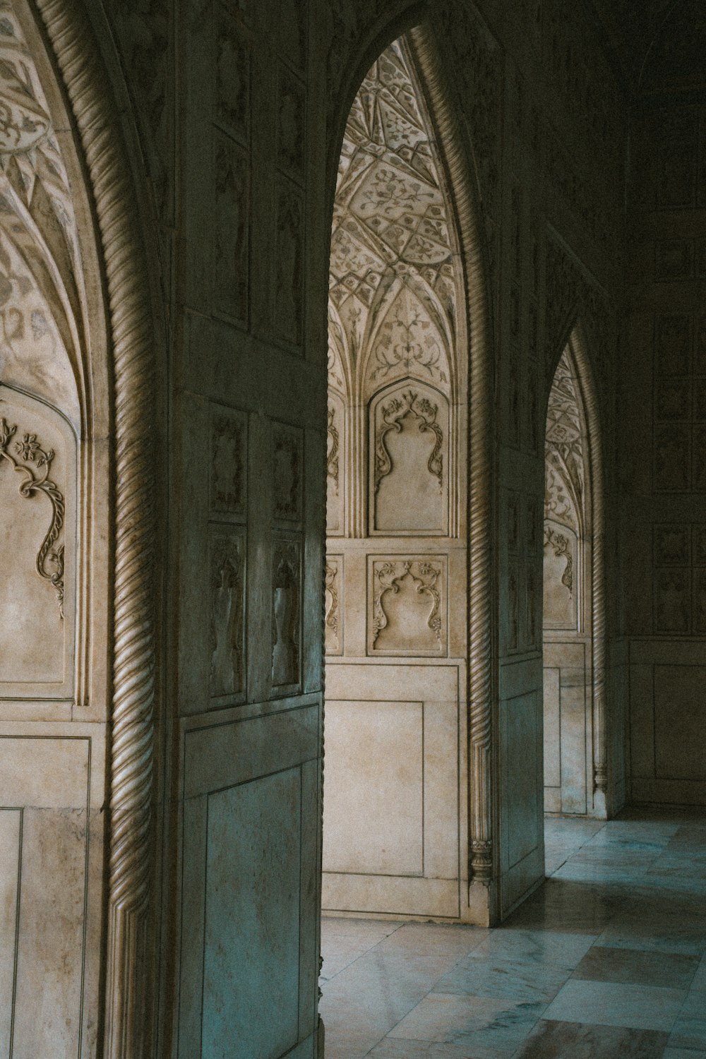 a room with a marble floor and arches