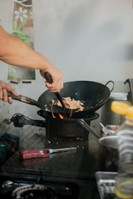 A chef expertly tossing fresh ingredients in a sizzling wok, flames rising in the background.