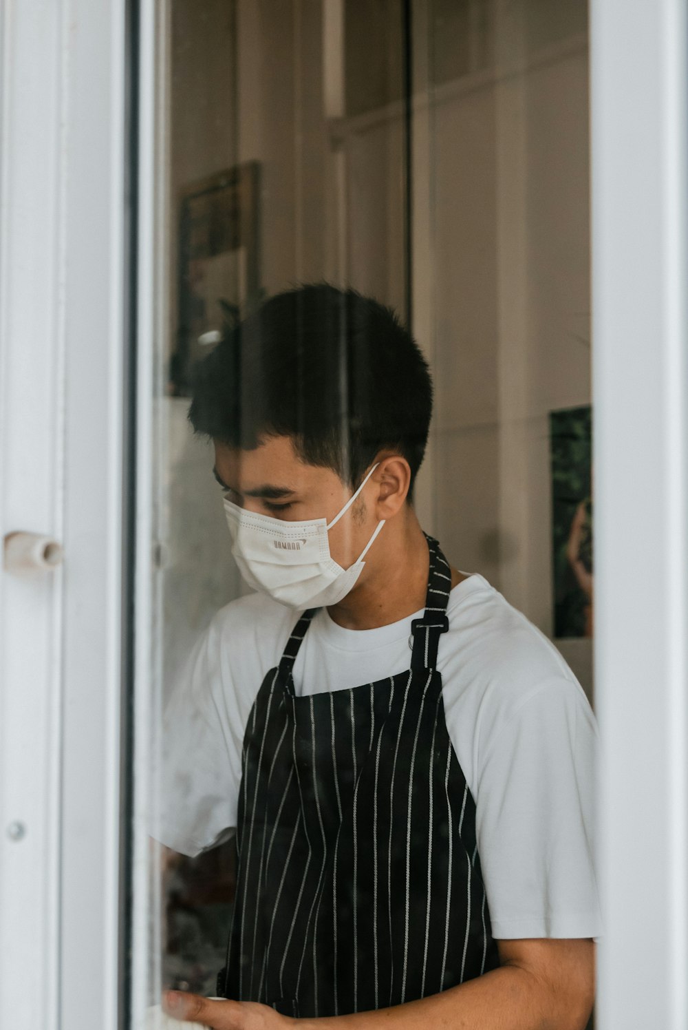 a man wearing a face mask while looking at his cell phone