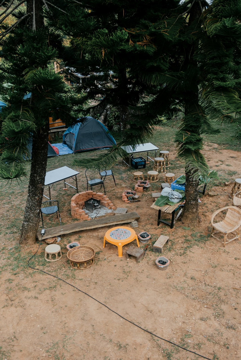 a camping area with a fire pit and chairs