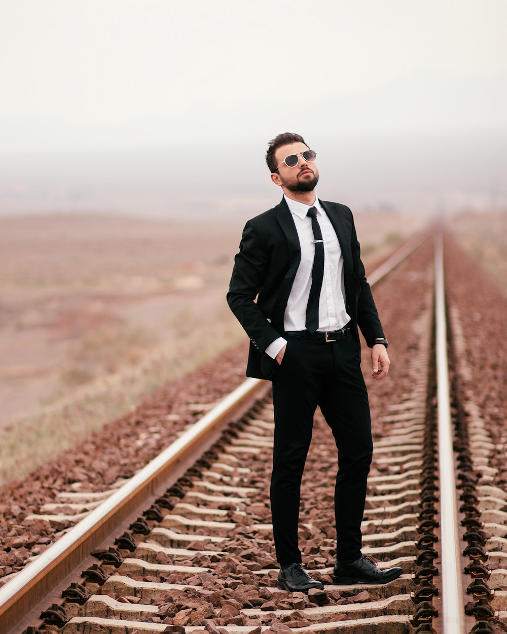 a man in a suit standing on a train track