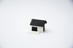 Modern house icon in gray and white tones representing residential insurance.