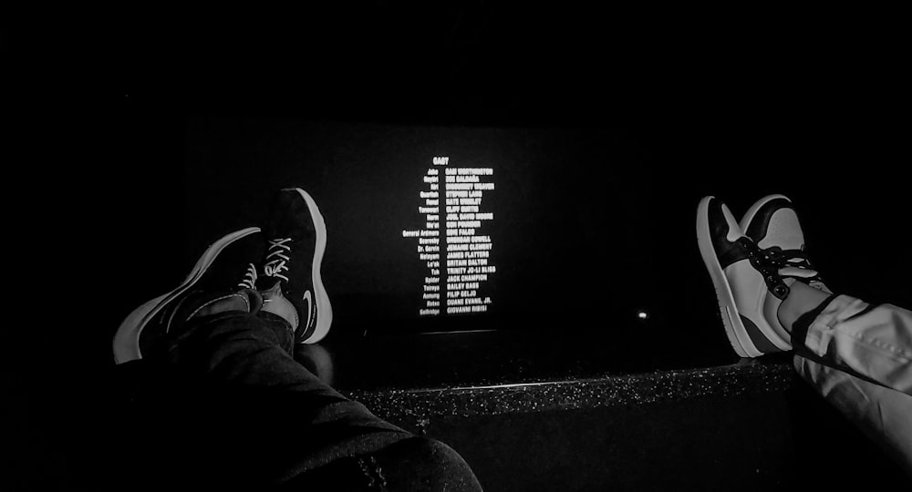 a black and white photo of a person's feet on a wall