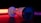 A surveillance camera is in focus, bathed in dramatic lighting with strong red and black tones. The brand name on the side is visible, and the camera's lens is slightly reflective. The background is dark, enhancing the illuminated effect of the camera.
