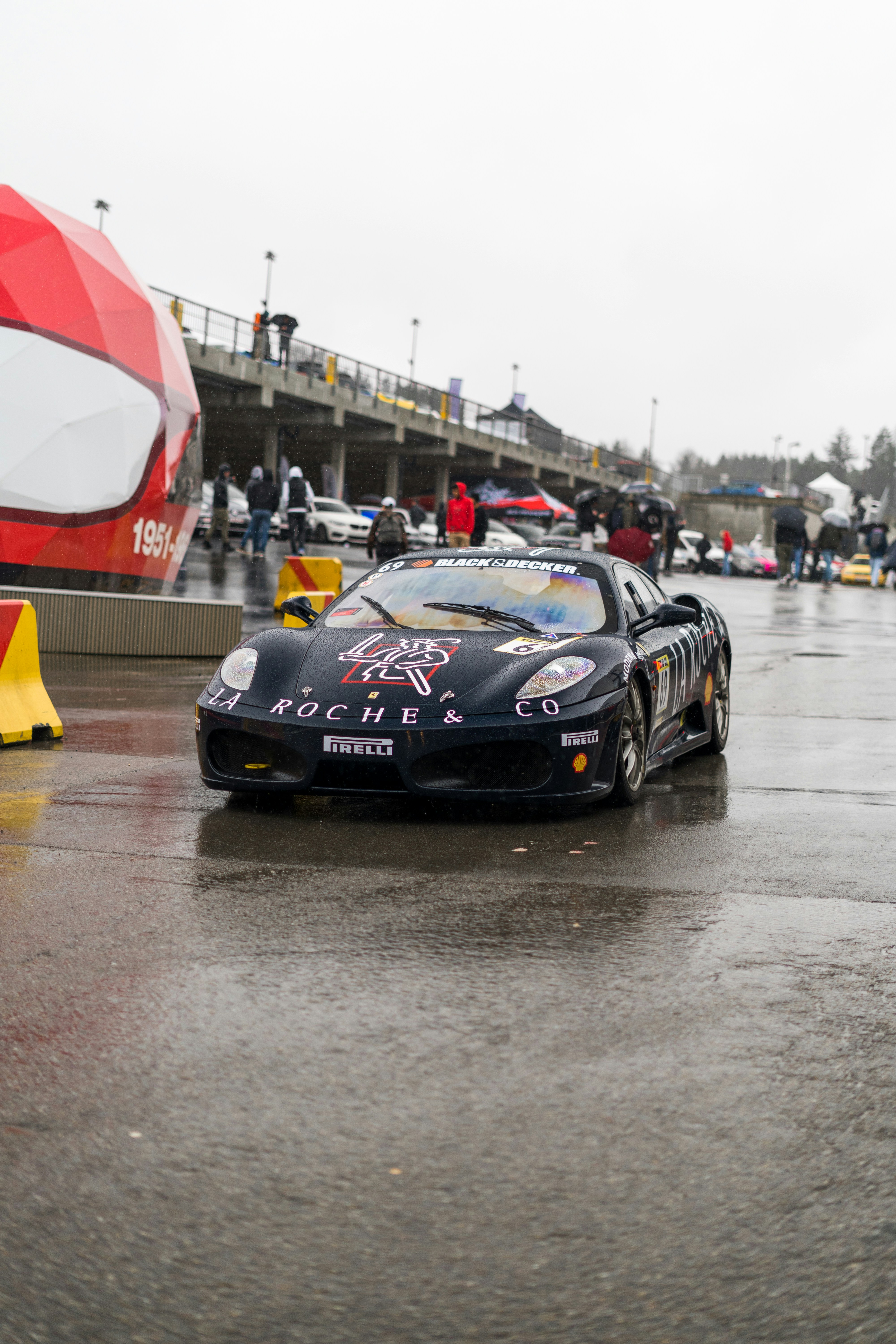 濡れた道路を走る黒いスポーツカー