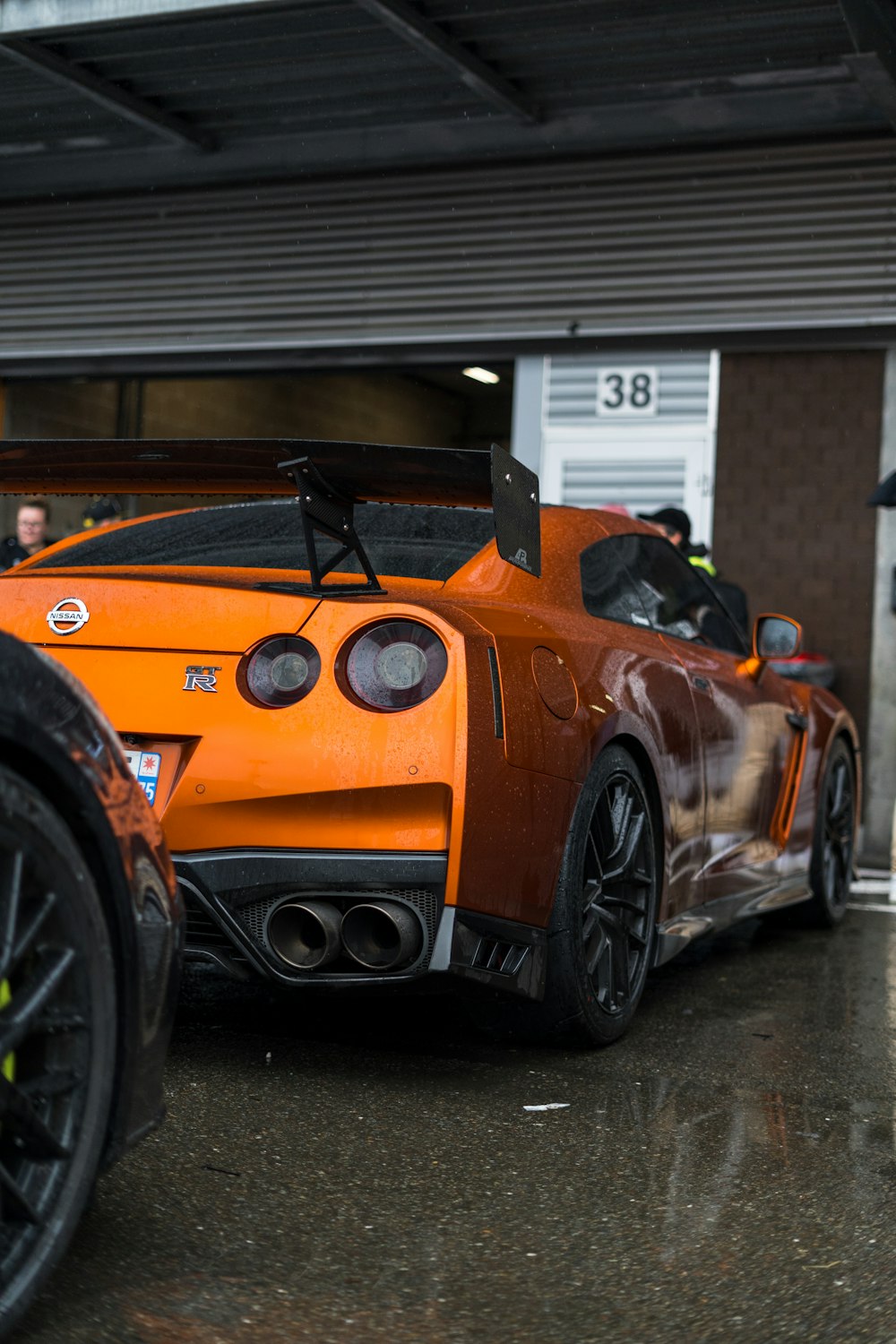an orange sports car parked in front of a building