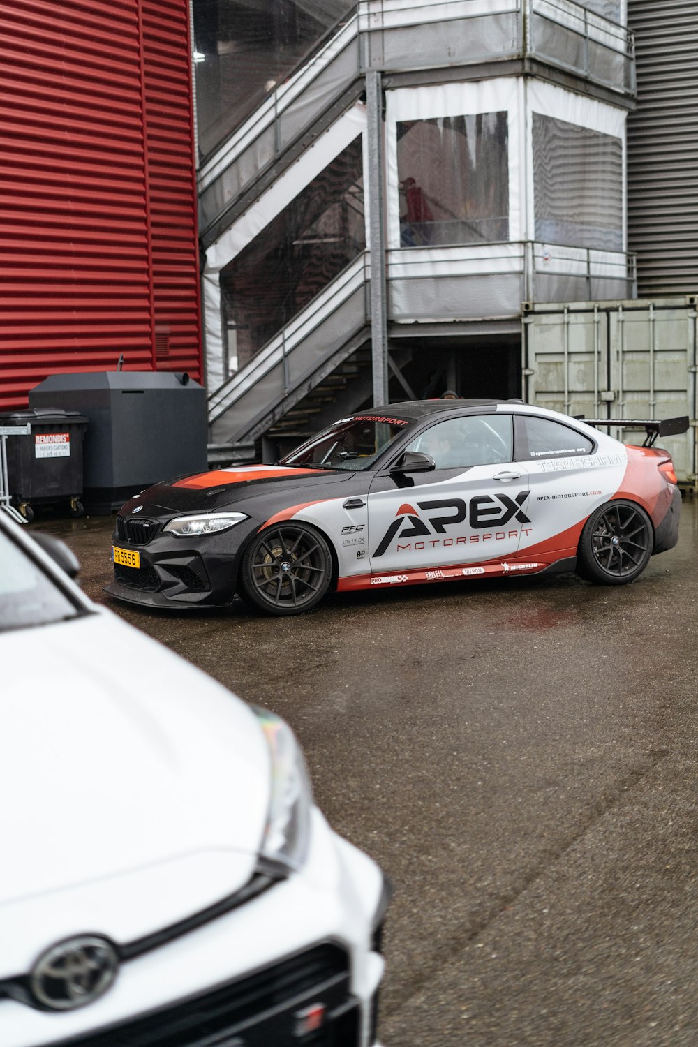 two cars parked next to each other in front of a building