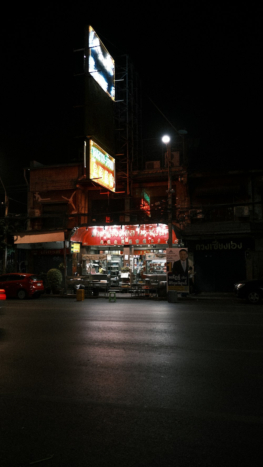 a dark street at night with a restaurant lit up