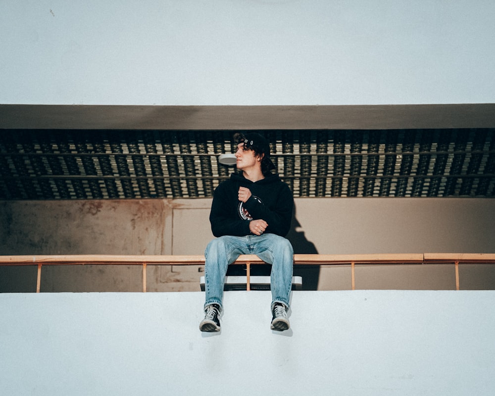 a man sitting on top of a wooden bench