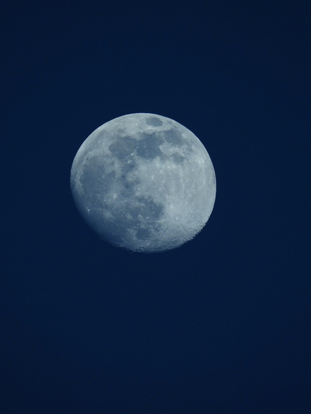 a full moon in a dark blue sky