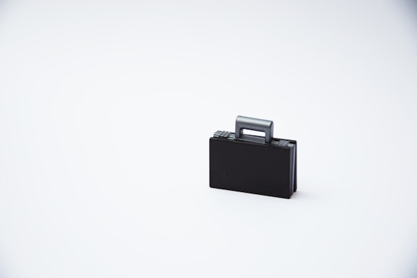 A sleek, structured suitcase in a vibrant color, standing upright with its handle extended against a clean, neutral background.