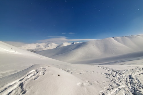a view of a snow covered mountain under a blue sky