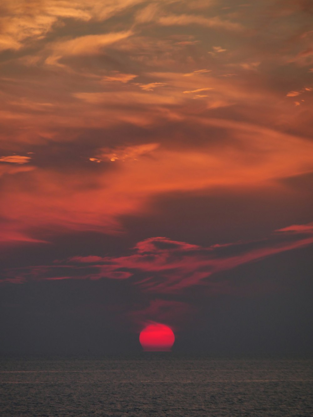 El sol se está poniendo sobre el océano en un día nublado