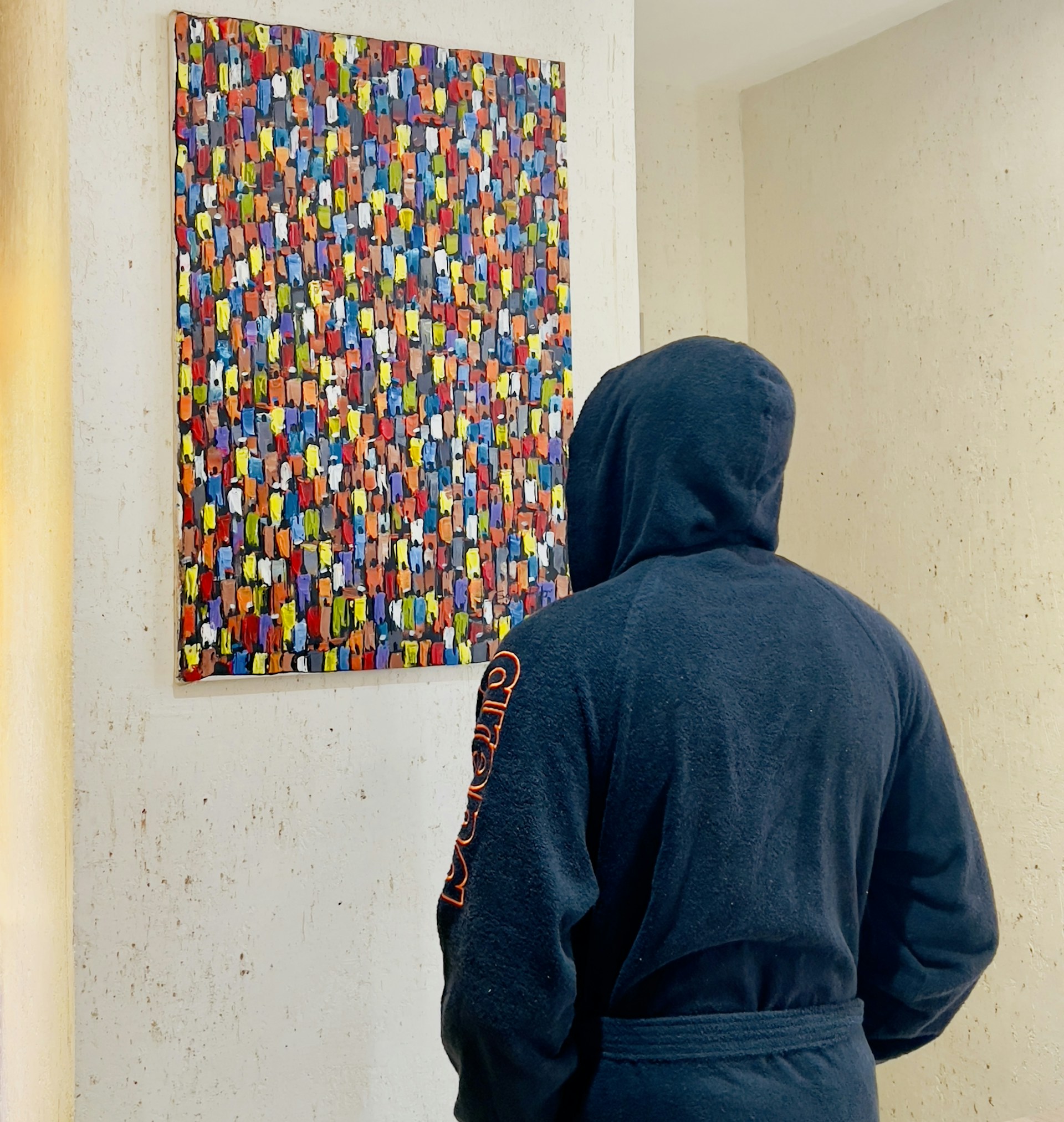 A close-up of a charcoal and burnt orange abstract painting printed on a soft cotton hoodie, highlighting the brushstroke textures.