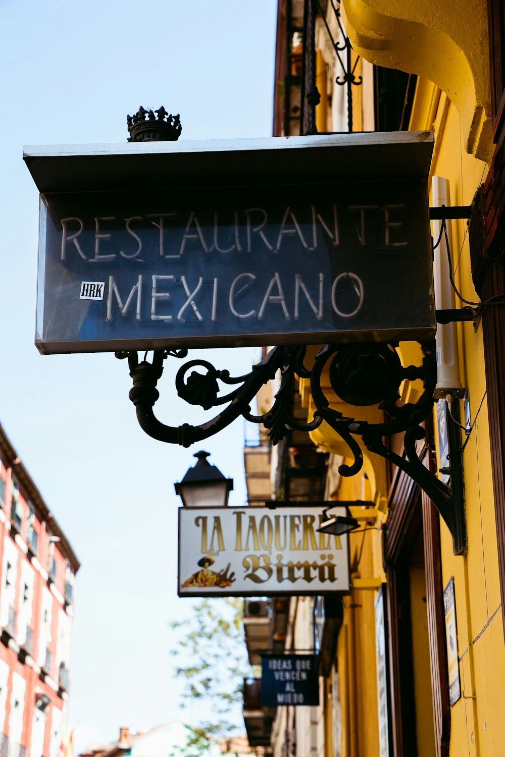 a restaurant sign hanging from the side of a building