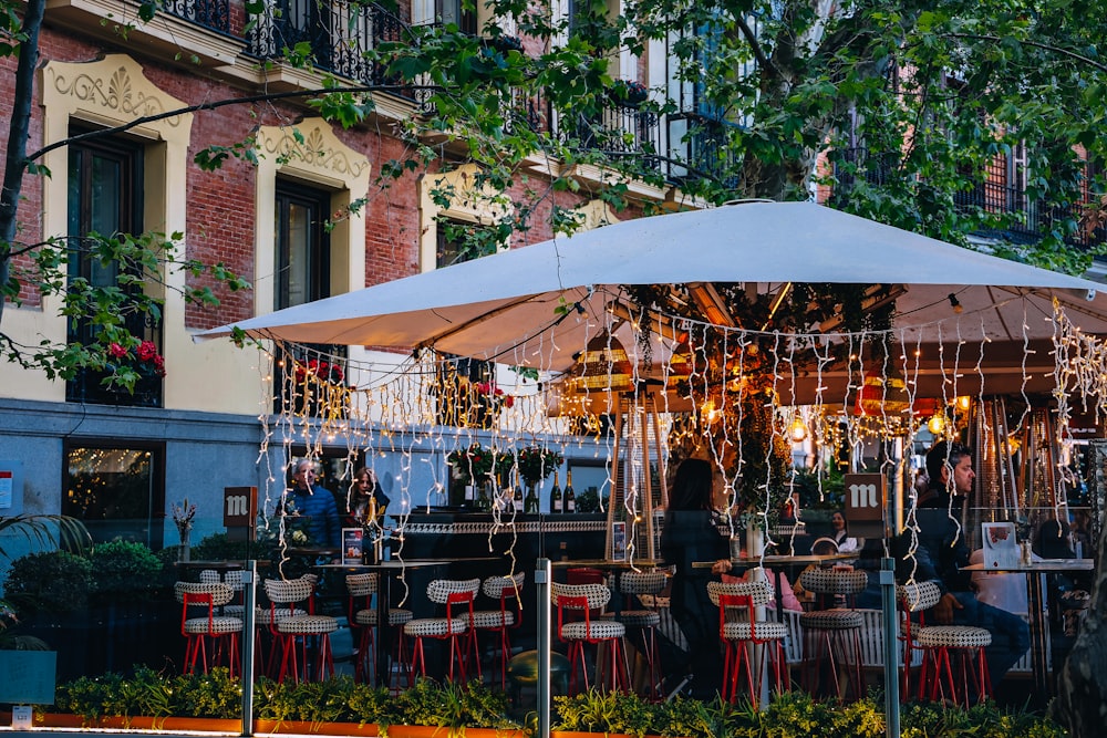 a group of people sitting at a table under an umbrella