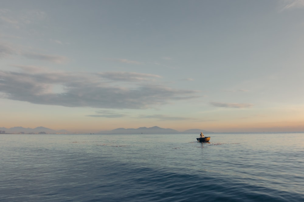 a small boat floating on top of a large body of water