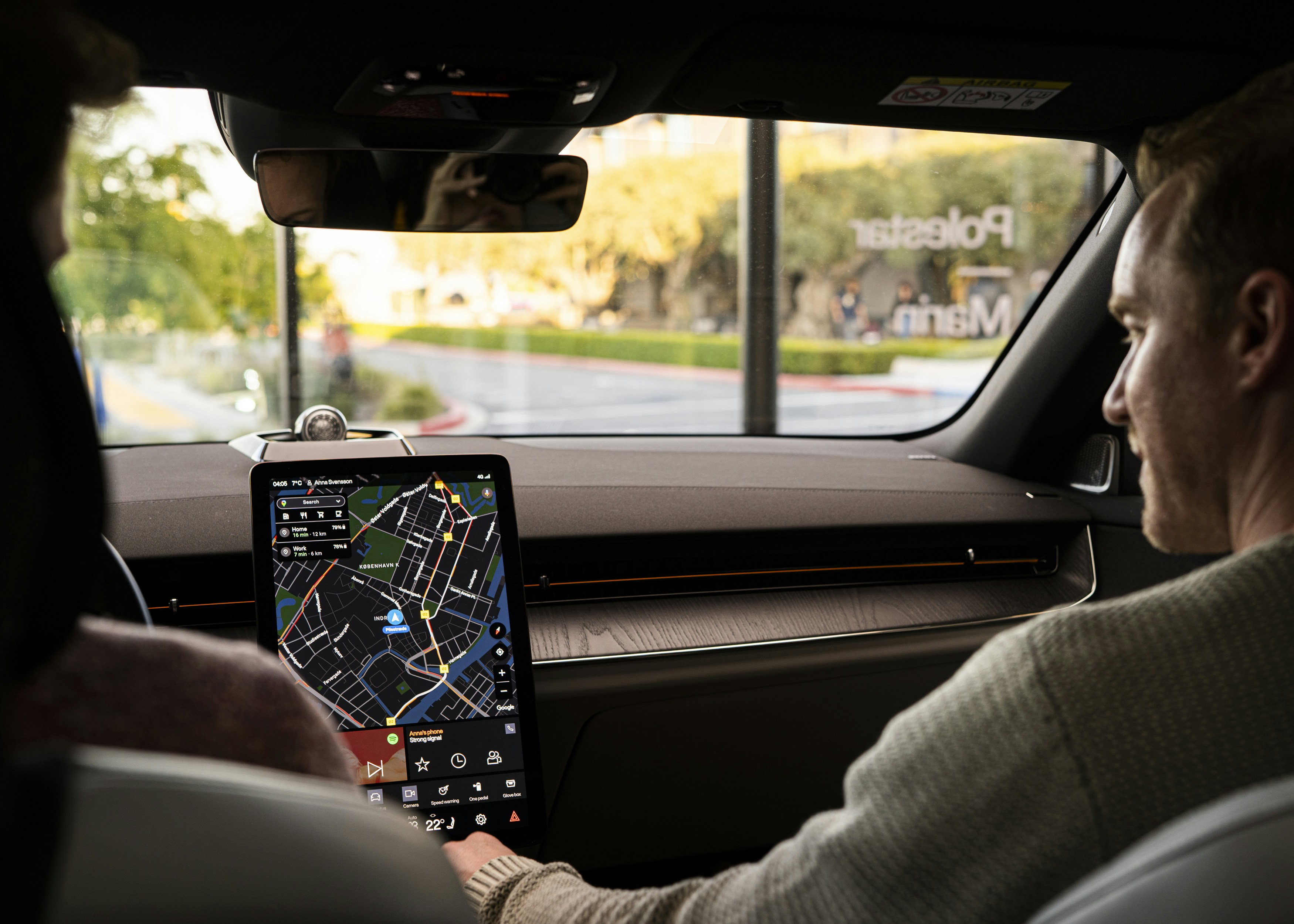 a man sitting in a car holding a tablet