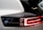 Close-up view of a car's rear light with sleek and modern design elements, featuring a prominent black and white color scheme. The brand name 'Polestar' appears next to the glowing red lights, indicating a focus on a contemporary and high-tech aesthetic.