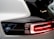 Close-up view of a car's rear light with sleek and modern design elements, featuring a prominent black and white color scheme. The brand name 'Polestar' appears next to the glowing red lights, indicating a focus on a contemporary and high-tech aesthetic.
