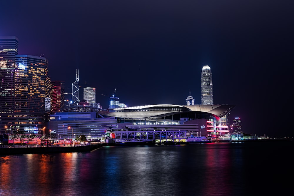 a city skyline at night with lights reflecting off the water