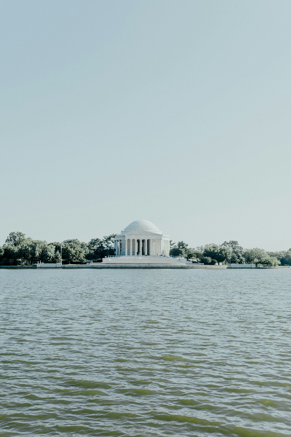 a large body of water with a building in the background