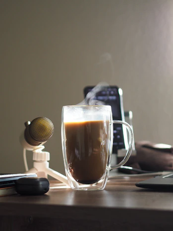 A warm, inviting workspace with a laptop, phone, and a cup of coffee ready for communication.