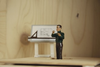 a figurine of a man taking a picture of a desk