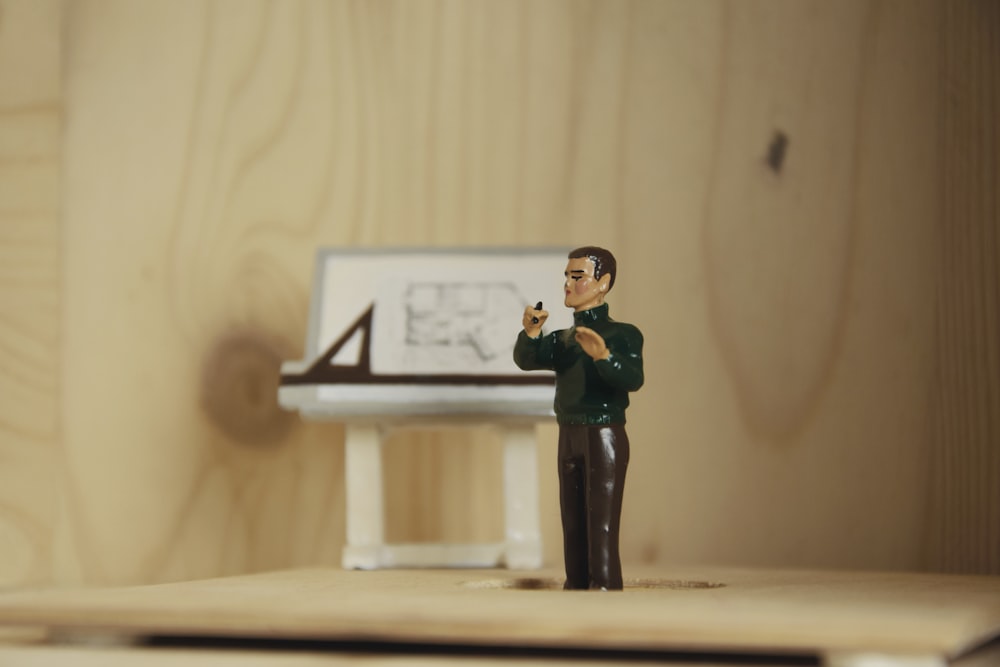 a figurine of a man taking a picture of a desk