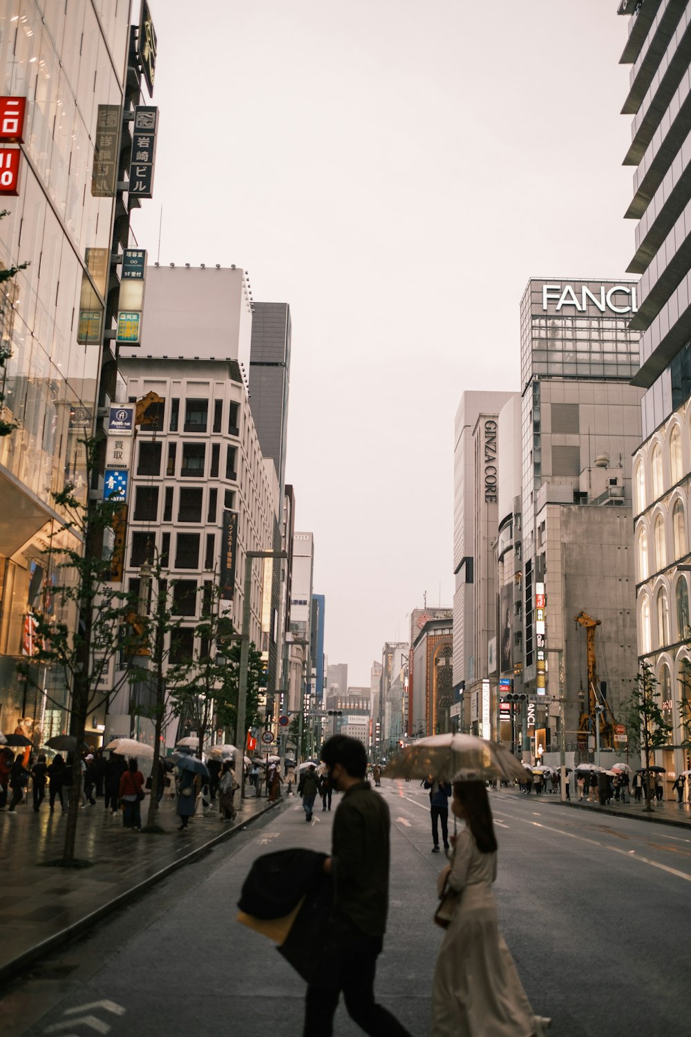 a couple walking down a street holding an umbrella