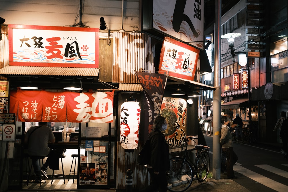 a person standing outside of a store at night