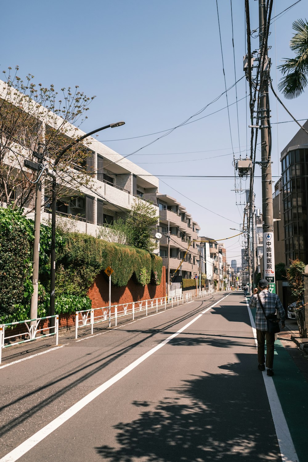 a man walking down a street next to a tall building