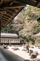 a japanese garden with rocks and trees in the background