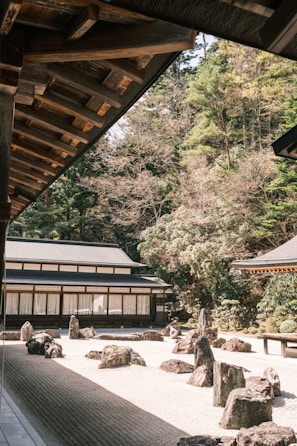 a japanese garden with rocks and trees in the background