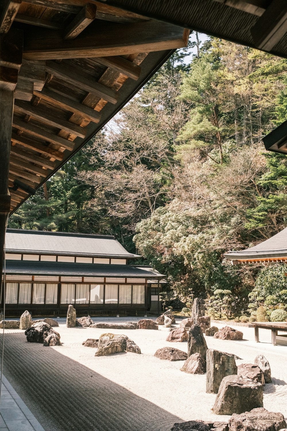 um jardim japonês com rochas e árvores ao fundo