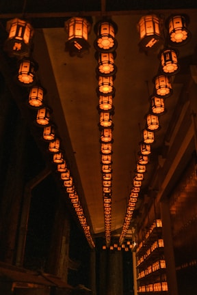 A peaceful corner with softly glowing lanterns and ancient scrolls hanging on the wall.