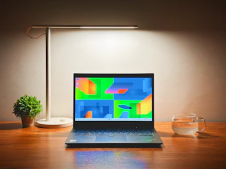 A clean, modern workspace with a laptop, coffee cup, and green plant reflecting a minimalist style.