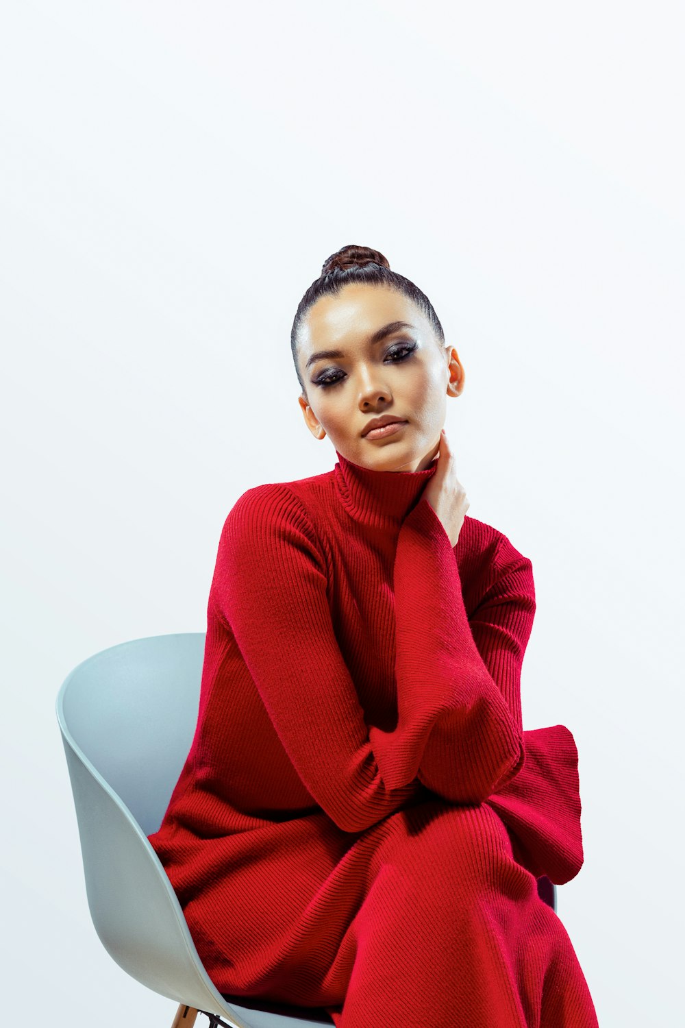 a woman in a red sweater sitting on a chair