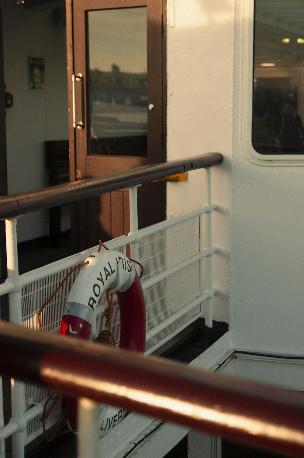 a red and white fire hydrant sitting on the side of a boat