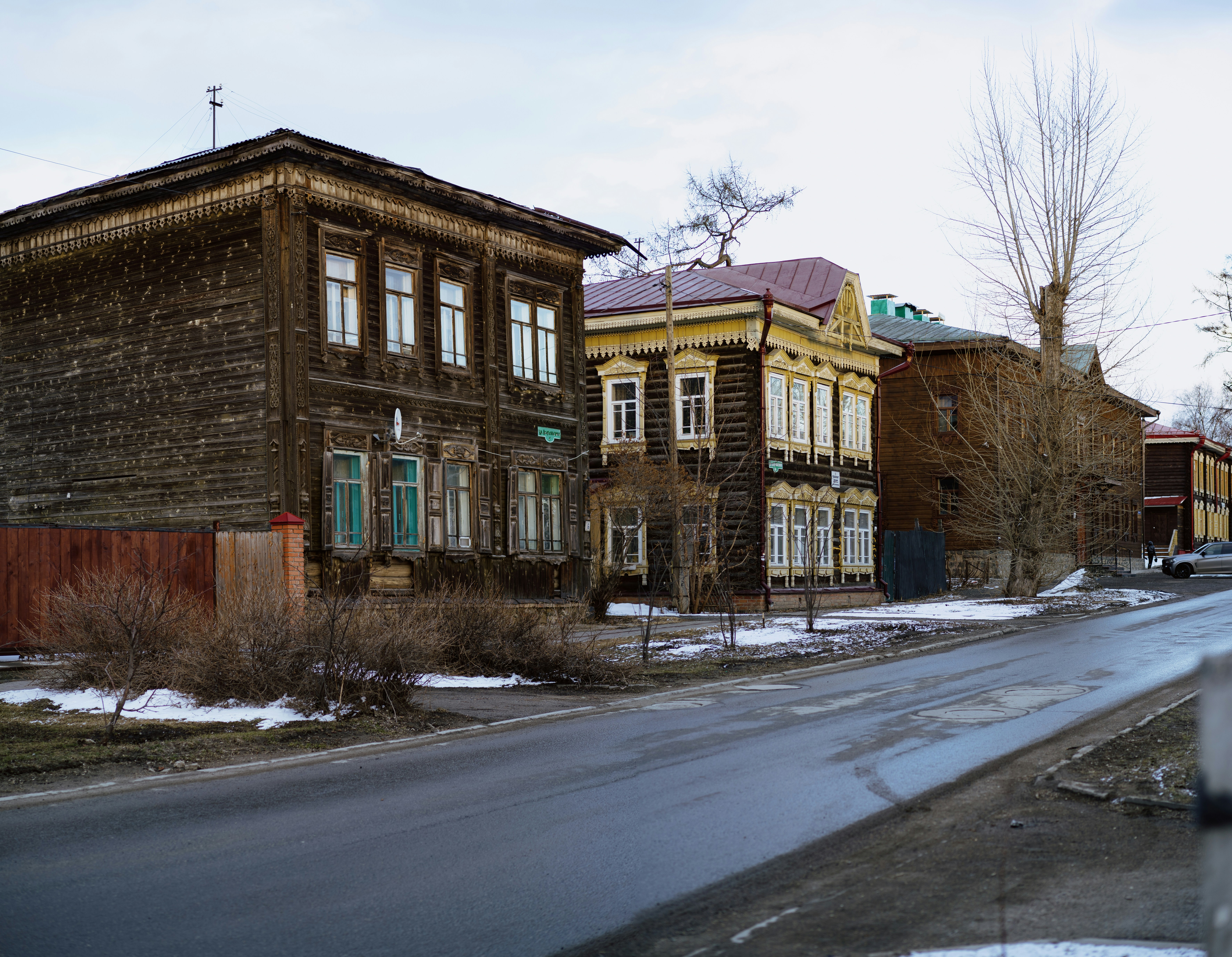 a row of old wooden buildings on a snowy street