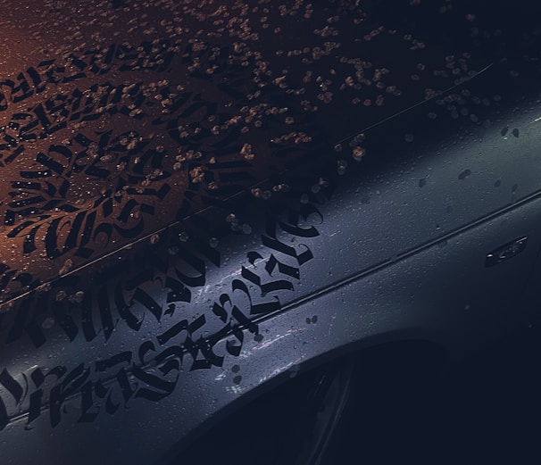 A craftsman applying vibrant vehicle lettering on a company van under bright daylight.