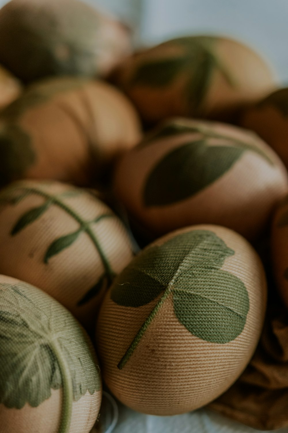 a bunch of eggs with leaves painted on them