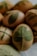 Eggs are decorated with green leaf patterns, likely created using a natural dyeing technique. The leaves appear to be pressed against the eggs, creating a detailed imprint of their veins and shapes. The colors are muted, with a soft focus that adds to an organic, rustic feel.