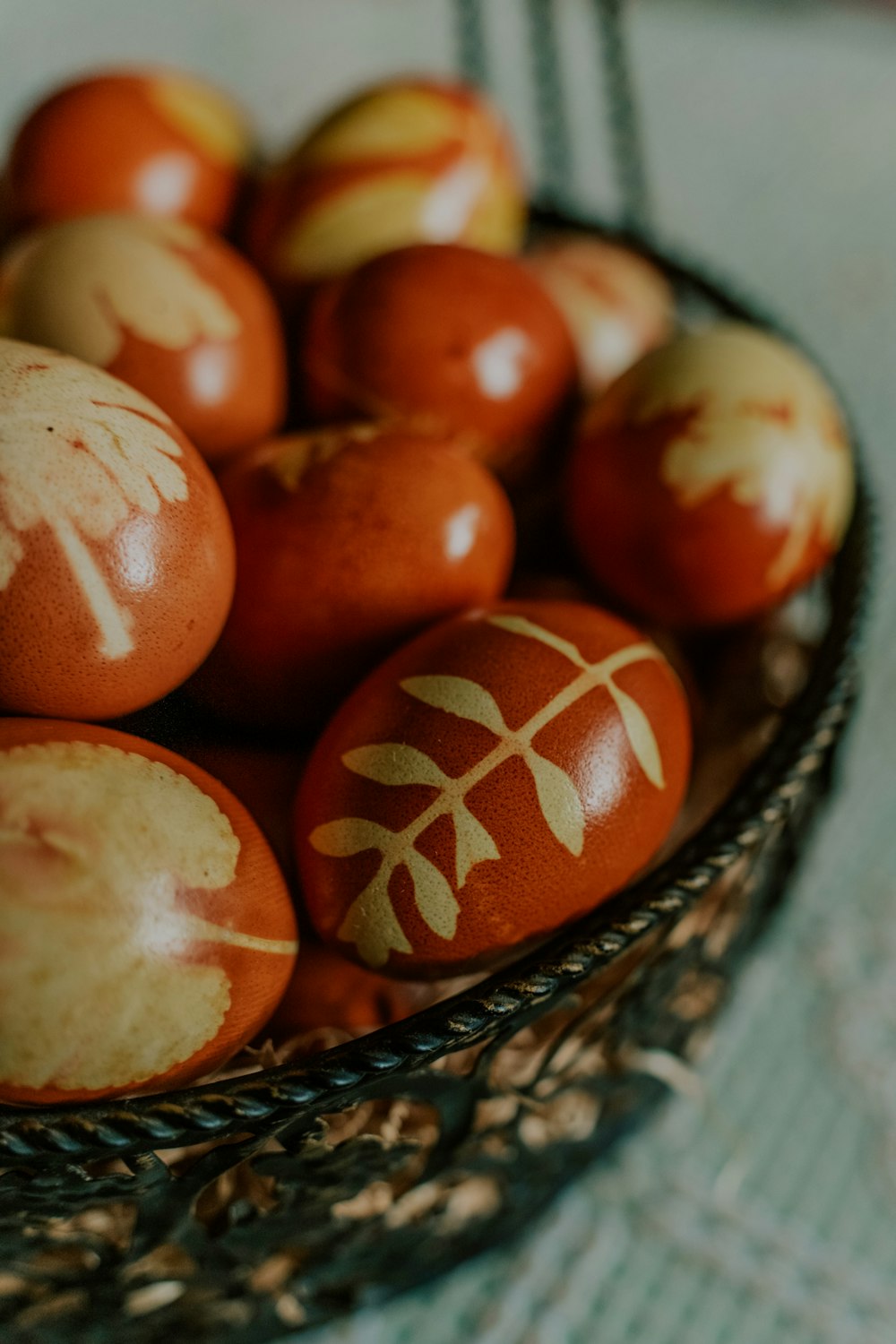 a basket filled with red and yellow painted eggs