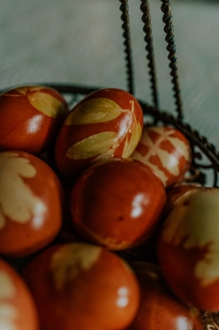 An assortment of hand-painted Easter eggs nestled in a rustic basket.