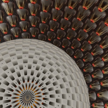An intricate and symmetrical pattern featuring a large circular design in the foreground with a textured, woven appearance. The background is filled with repeated cone-shaped elements, each with a glossy surface and a red tip, creating a sense of depth and complexity.