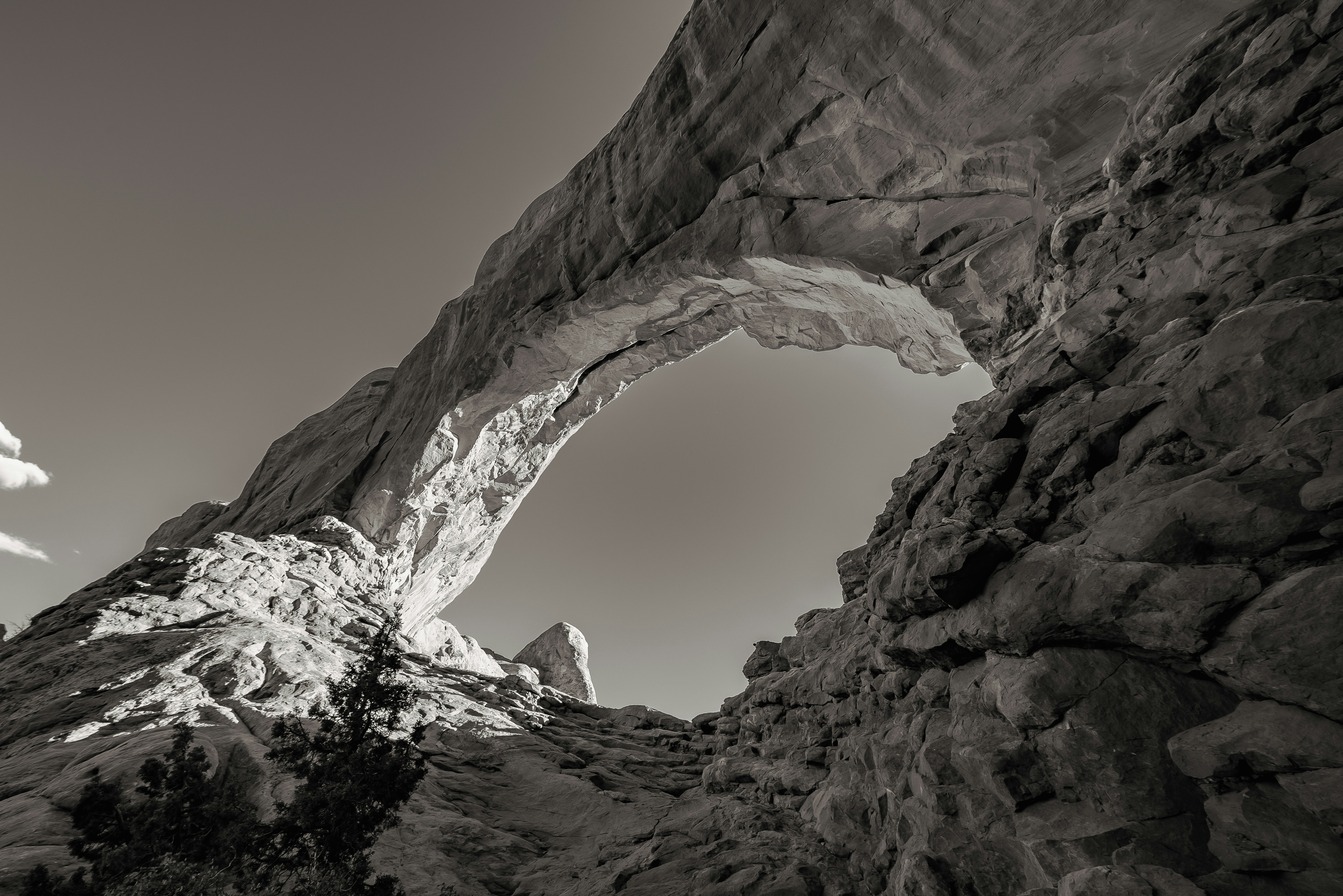 a black and white photo of a rock arch
