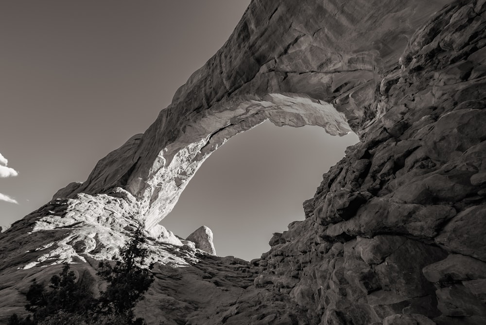 a black and white photo of a rock arch